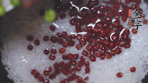 將炒好的食材和大米、紅豆一起放進(jìn)電飯鍋煮。