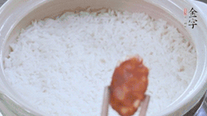 煮開后轉小火，當米飯出現小孔時，鋪上金字麻辣香腸。