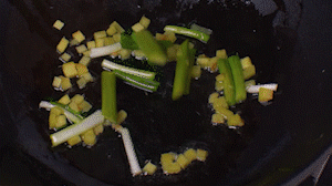 鍋中熱油，依次下姜粒、蔥段、蘆筍炒香。