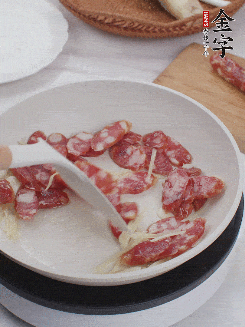 油溫3成熱時(shí)，下姜絲、蒜片、香腸炒出油脂。