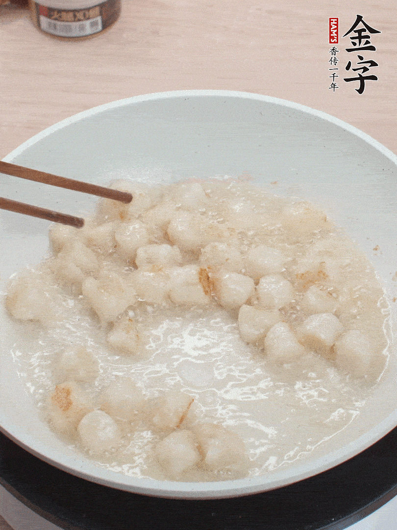 油溫4成熱，鮮貝蘸干淀粉下鍋煎，一面微黃后翻面。