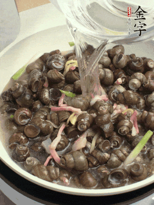 倒處理干凈的螺螄翻炒，加3勺料酒。加清水蓋過(guò)螺螄，中火蓋蓋煮5分鐘。