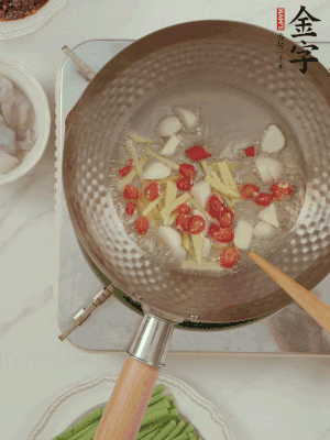 油7成熱時(shí)，下大蒜粒、姜絲、小米辣煸香。