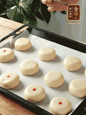 收口向下放在案板上，輕輕將月餅坯按扁，用筷子點紅點做裝飾