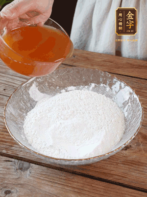 轉(zhuǎn)化糖漿、枧水、花生油攪拌均勻，加入面粉混合，醒發(fā)2小時。捏成23g一個的小球